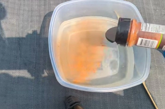 image of adding cayenne pepper powder in water to make a mixture